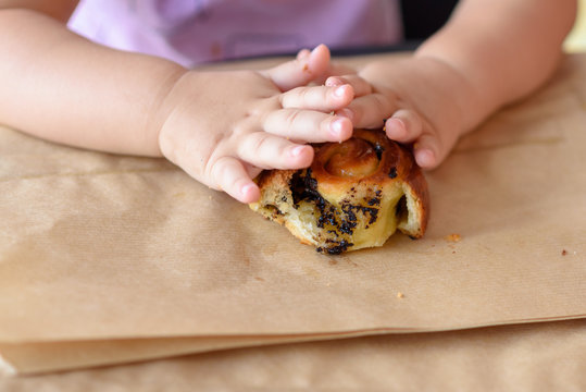 Kid Devours Croissant Or Bun Roll Chocolate .Close Up Hand Little Girl Having Breakfast In Cafe On The City Street. The Child Is Eating A Croissant. Breakfast Black Table In Restaurant Eco Paper Bag.