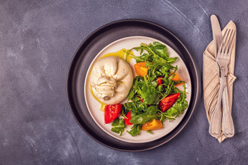 Italian cheese Burrata with fresh arugula, tomatoes, olive oil