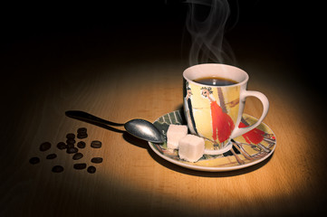 Coffee cup, spoon and coffee beans on a wooden table
