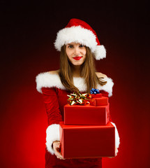 Beautiful woman in Santa Claus clothes holding gift boxes