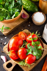 Healthy food: fresh vegetables on the kitchen table in a rustic style. Fresh tomatoes, cucumbers and rucola for cooking salad. Diet menu.