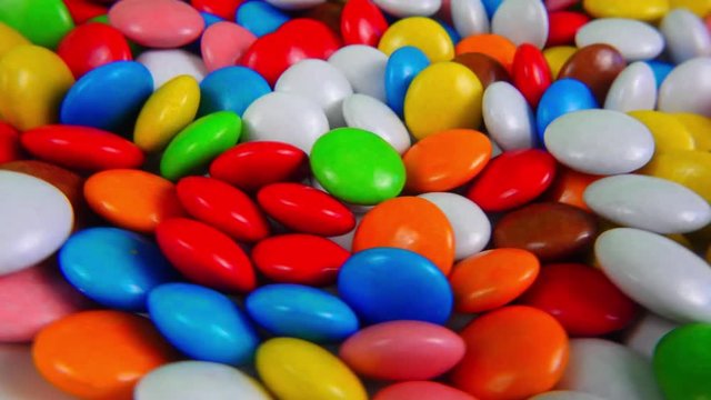 Multicolored candy, dragee on a plate, close-up.