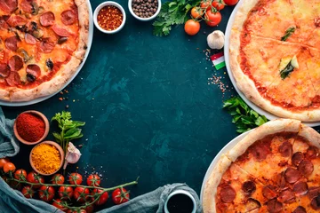 Foto auf Glas A set of pizza. Italian cuisine. On a black stone background. Free copy space. Top view. © Yaruniv-Studio