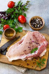 Fresh raw meat. Raw pork meat fillet with tomatoes, olive oil, spices and herbs on wooden table. Copy space.