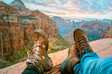 Close up of couple wearing mountain boots and landscape of mountains