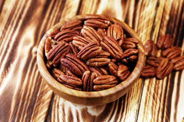 Pecan nuts on a table and pecan nuts in bowl