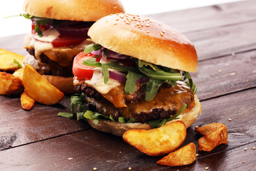 Tasty fresh meat burgers with salad and cheese and potato wedges. Homemade angus burger.