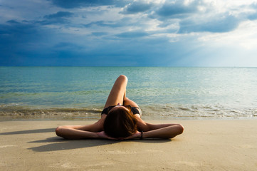 Fototapeta na wymiar Leisure in summer - Young woman lying and relax on a tropical beach. Summer vacation concept.