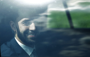 successful businessman looking out the window of a car