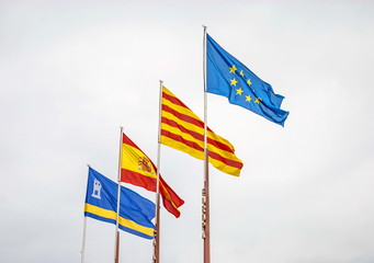 Flags of the European Union, Spain, Catalonia against the background of the cloudy sky