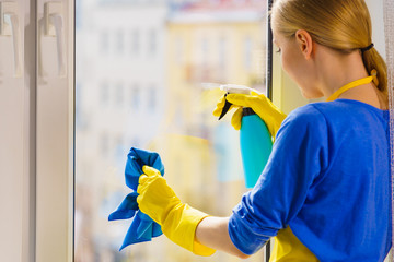 Woman cleaning window at home