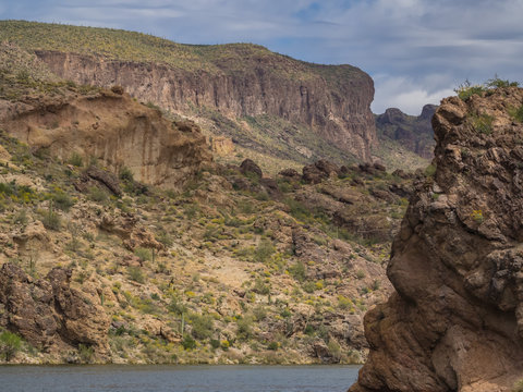 Dramatic cliffs rise above both sides of Canyon Lake along the Apache Trail in the Superstition Mountains in the American southwestern state of Arizona