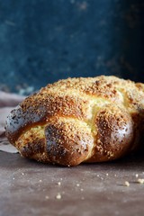 Challah or Hala is a traditional jewish sweet fresh sabbath bread loaf,  fresh bun on cutting board. Brioche bread on breakfast table. The golden glaze of these baked brioche buns boasts 