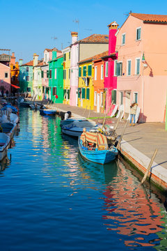 view of colorful houses and boats of Burano island at sunny day, Venice, Italy