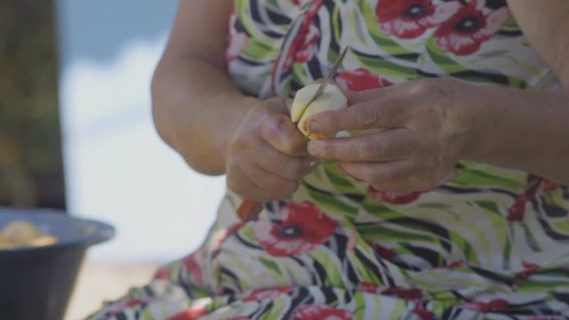 Close-Up Elderly Woman Slices Apple for Making Apple Pie