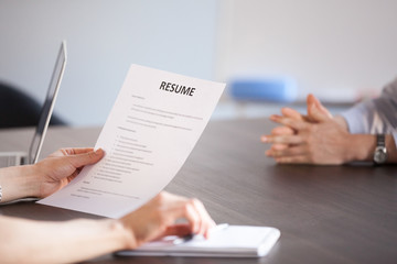 Hands of hr holding paper resume at job interview, recruiter or employer reading cv application of...