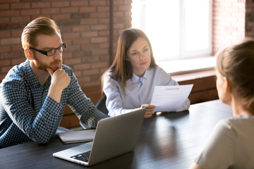 Distrustful unconvinced hr managers looking suspicious interviewing applicant feeling skeptical...