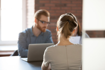 Rear view at young woman applicant seeker at job interview concept, open vacancy position candidate...