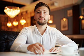 Young businessman at table in cafe