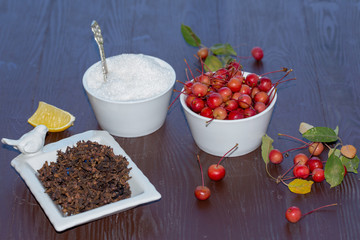 wild tiny apples with sugar cloves and lemons waiting to be jam on wooden background