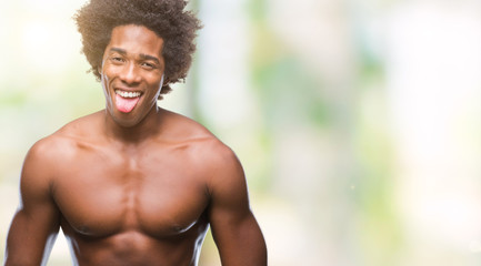 Afro american shirtless man showing nude body over isolated background sticking tongue out happy...