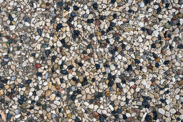 Texture of multi-colored stone mosaic on a paved road by the sea, top view, Flatley