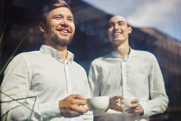 Cheerful young businesspeople with coffee cups