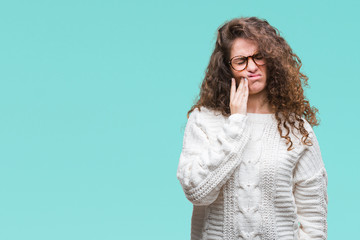 Fototapeta premium Beautiful brunette curly hair young girl wearing winter sweater over isolated background touching mouth with hand with painful expression because of toothache or dental illness on teeth. Dentist