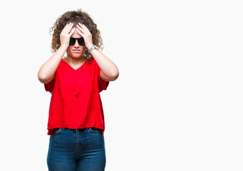 Beautiful brunette curly hair young girl wearing sunglasses over isolated background suffering from headache desperate and stressed because pain and migraine. Hands on head.