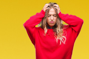 Beautiful young blonde woman wearing winter sweater over isolated background suffering from headache desperate and stressed because pain and migraine. Hands on head.