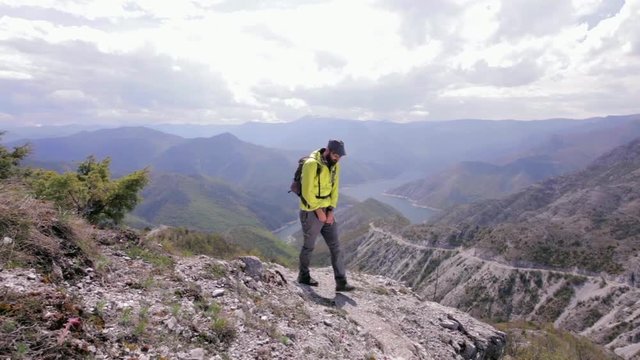 Man urinating in nature with beautiful scenery. Dolly shot