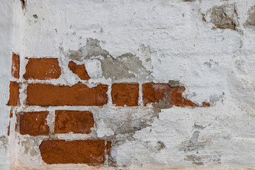 A brick wall partially covered with paint. 