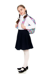 Beautiful schoolgirl with a backpack behind her shoulders.