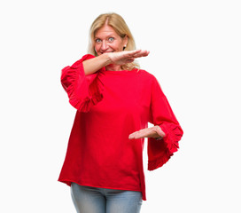 Middle age blonde woman over isolated background gesturing with hands showing big and large size sign, measure symbol. Smiling looking at the camera. Measuring concept.
