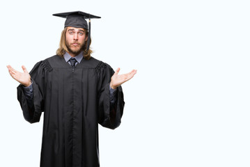 Young handsome graduated man with long hair over isolated background clueless and confused expression with arms and hands raised. Doubt concept.