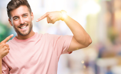 Young handsome man over isolated background smiling confident showing and pointing with fingers teeth and mouth. Health concept.