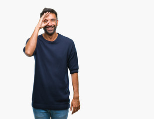 Adult hispanic man over isolated background doing ok gesture with hand smiling, eye looking through fingers with happy face.