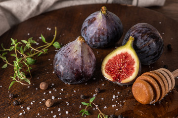 Fresh figs. Whole figs and sliced in half figs on wooden cutting board.