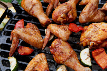 Meat and vegetables during grilling. Assorted types of chicken
