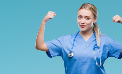 Young blonde surgeon doctor woman over isolated background showing arms muscles smiling proud....