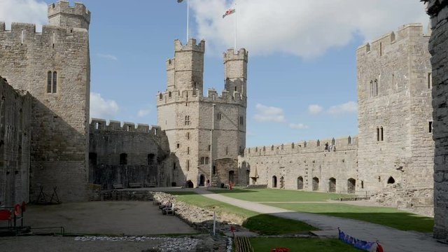 Far distant unidentifiable visitors at Caernarfon Castle a medieval fortress in Caernarfon, Gwynedd, north-west Wales
