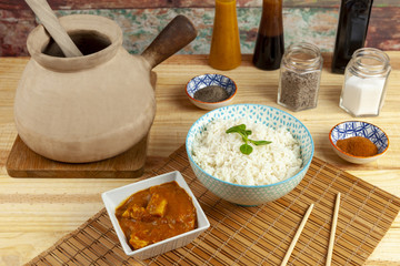 Curry and rice along side a traditional Chinese cooking pot