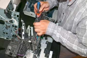 Repair of the laser copier-printer in the service center. Replacing worn gears.
