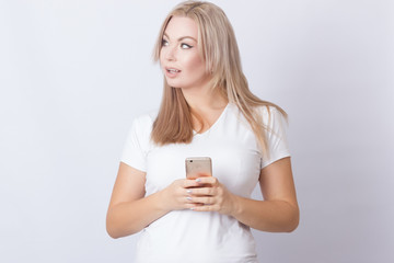 Woman holding mobile phone and looking away