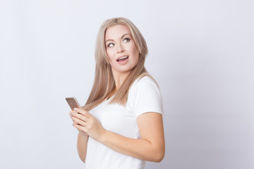 Woman holding mobile phone and looking away
