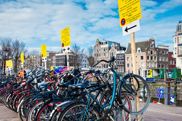 Bunch of bicycles parked next to the canal at Old Central district in Amsterdam