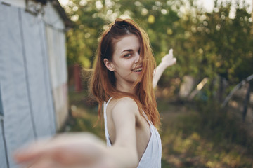 happy woman shows finger to trees on nature