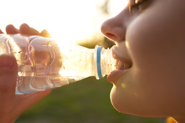 smiling woman drinking water from a bottle