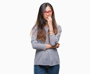 Young asian woman wearing glasses over isolated background looking stressed and nervous with hands on mouth biting nails. Anxiety problem.