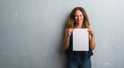 Middle age hispanic woman holding bank paper sheet with a happy face standing and smiling with a...